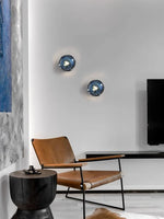 Lampe murale bleue dans un salon avec canapé gris