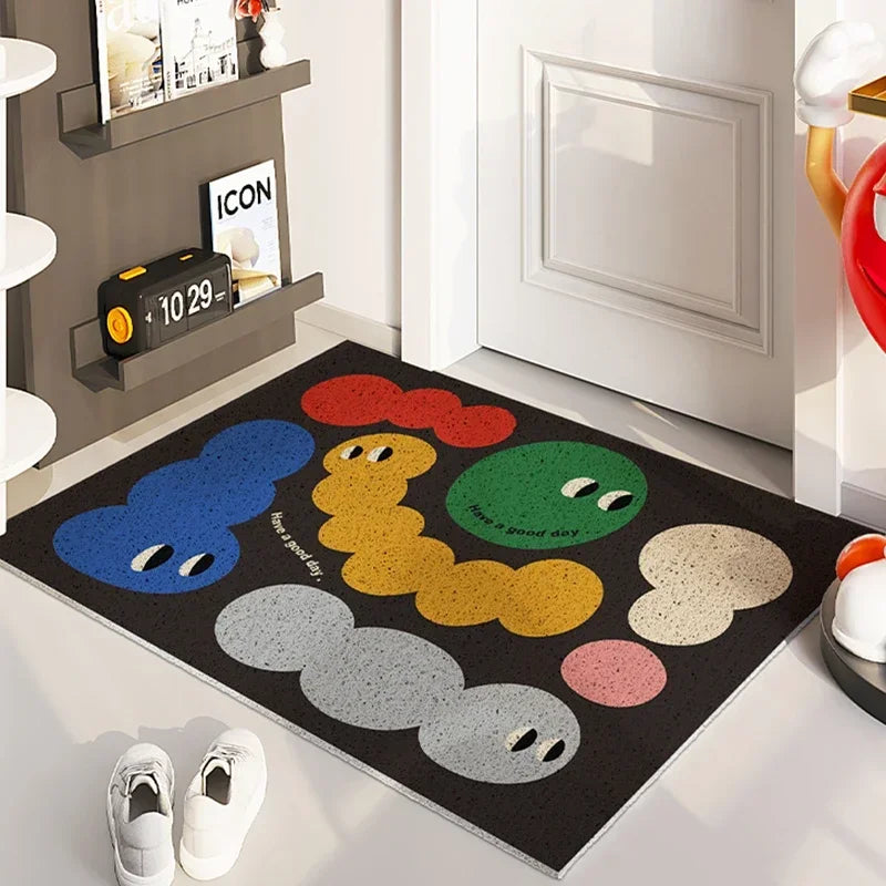 Tapis d'entrée décoratif avec motifs colorés de personnages expressifs sur un fond noir, créant une atmosphère chaleureuse et invitante dans l'espace.
