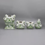 Ensemble décoratif de porcelaine blanche et verte orné de motifs floraux, composé de plusieurs vases et pots aux formes élégantes.