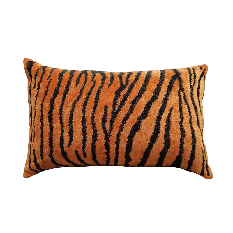 Un coussin rectangulaire en velours avec un motif de rayures couleur fauve, évoquant le pelage d'un tigre.