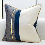 Un coussin décoratif élégant avec des motifs graphiques bleus et un design moderne.