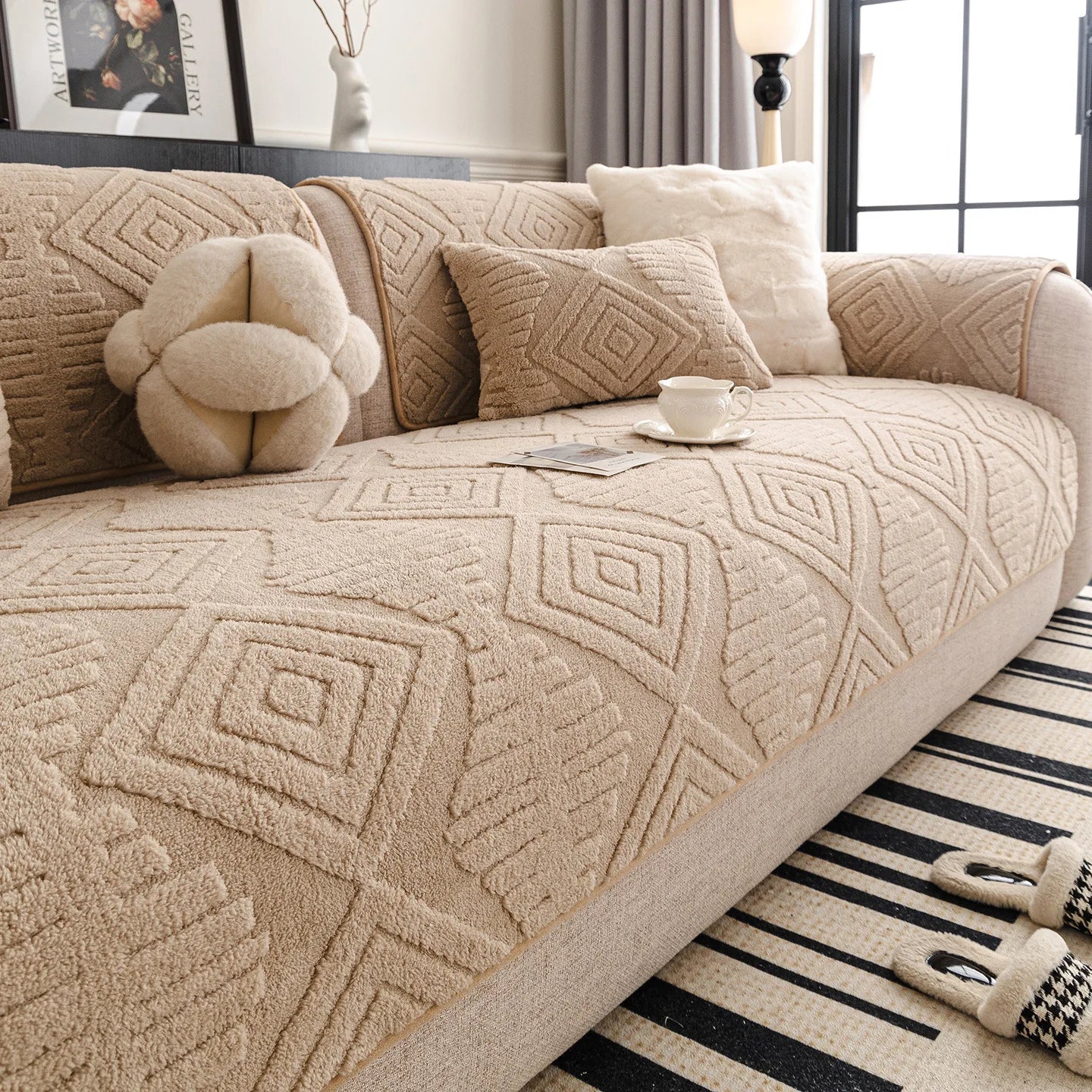 Un canapé confortable avec des motifs géométriques beiges et des coussins douillets, créant une atmosphère chaleureuse et accueillante dans la pièce.