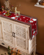 Commode en bois décorative avec motifs sculptés et accessoires de Noël posés sur le dessus, créant une ambiance chaleureuse et festive.