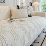 Un magnifique canapé blanc et douillet, avec des coussins coordonnés, offre un confort et une atmosphère chaleureuse dans cette pièce lumineuse.