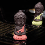 statuette bouddha artisanale couleur noir orange jaune bleu texture granulée méditatif argile violette