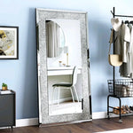 Un grand miroir encadré de métal gris et blanc, reflétant une chambre moderne avec des touches de style industriel.