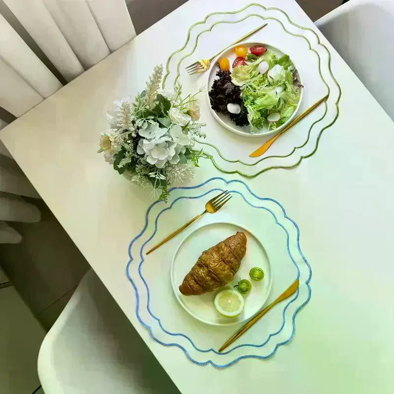 serviette table moderne blanc bleu clair bordure fine bords ondulés assiettes fourchettes dorées salade