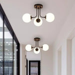 luminaire moderne or noir globes verre opaques semi suspendus métal
