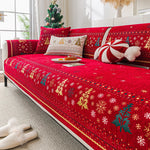 Un canapé rouge avec des motifs hivernaux et des décorations de Noël, créant une atmosphère chaleureuse et festive.