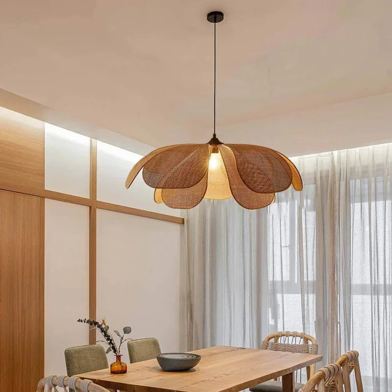 Lampe suspendue rotin allumée avec éclairage chaud dans une salle à manger