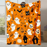 Une couverture en orange vif ornée de motifs d'Halloween, avec des fantômes, des citrouilles, des chauves-souris et d'autres symboles festifs.