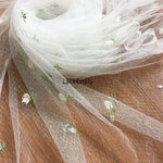 tissu dentelle transparent brodée motifs floraux roses feuilles romantique blanc rose vert