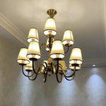 chandelier bronze classique suspension lumière abat jours tissu texturé courbes salle manger