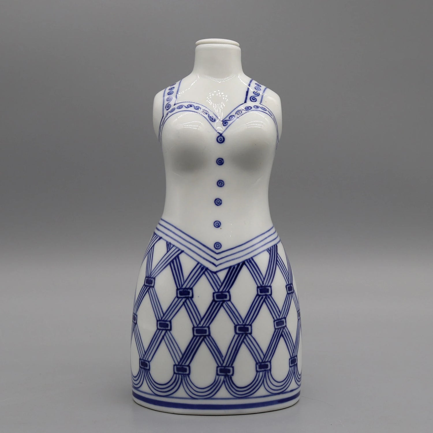 Une statuette de céramique blanche avec des motifs bleus décoratifs.