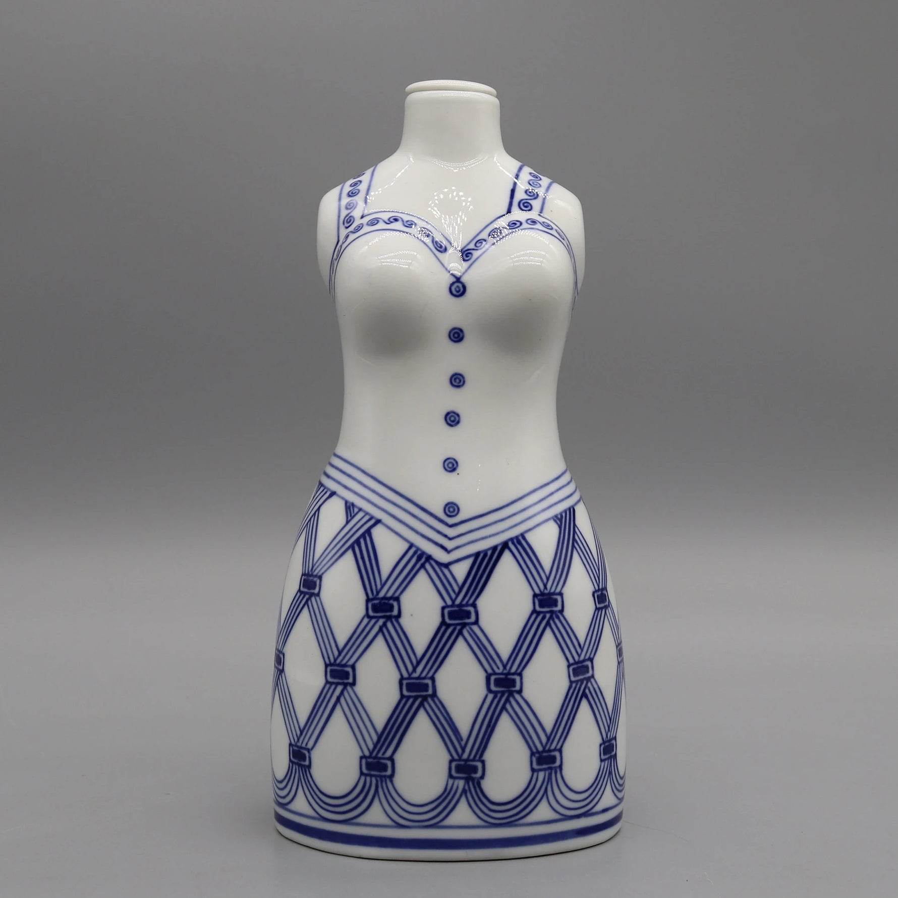 Une statuette de céramique blanche avec des motifs bleus décoratifs.