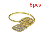 Bague dorée ornée de pierres étincelantes en forme de feuille.