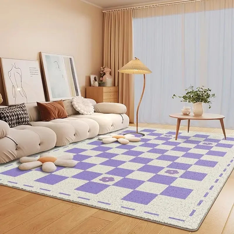 Un salon cosy et lumineux avec un canapé moelleux, des cadres muraux, une table basse et une lampe sur pied, le tout posé sur un tapis à carreaux violet et blanc.