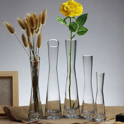 Petit vase en verre transparent avec fleurs blanches sur table en bois