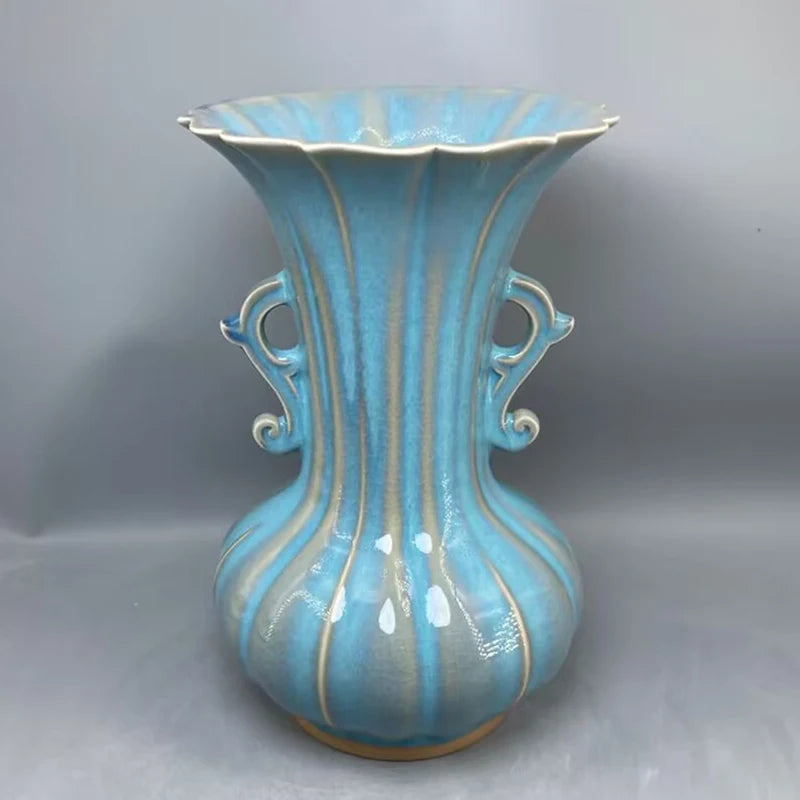 Vase en céramique turquoise aux formes élégantes avec des détails ouvragés.