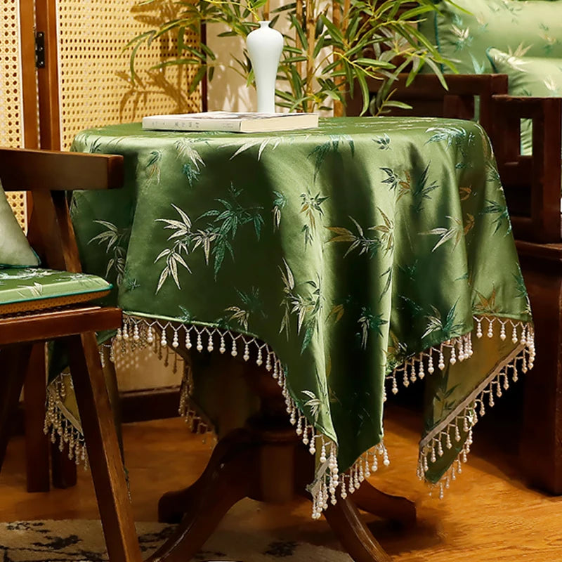 La nappe décorative verte foncée avec des motifs de bambou est posée sur une table en bois, créant une atmosphère tropicale et chaleureuse dans cette pièce.