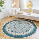 Un tapis rond avec un motif de mandala ornemental aux couleurs élégantes, posé sur un parquet dans un salon lumineux et décoré avec soin.