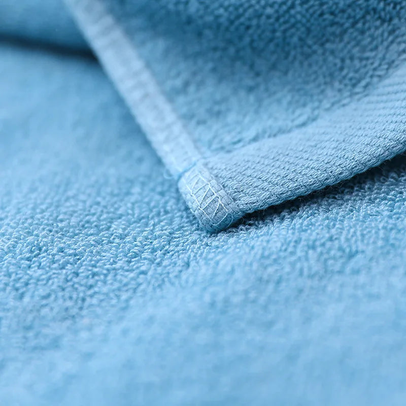 Un gros plan détaillé sur le tissu moelleux et bleu d'une serviette, révélant la texture et le motif caractéristiques d'un textile de haute qualité.
