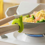 Repose-cuillère en silicone fixé à une poignée de casserole