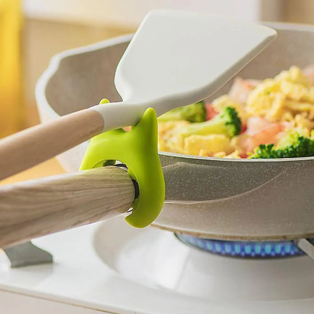 Repose-cuillère en silicone fixé à une poignée de casserole