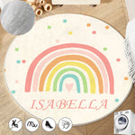 Un tapis rond en peluche décoré d'un arc-en-ciel coloré et du nom "Isabella" pour une chambre d'enfant chaleureuse et accueillante.