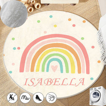 Un tapis rond en peluche décoré d'un arc-en-ciel coloré et du nom "Isabella" pour une chambre d'enfant chaleureuse et accueillante.