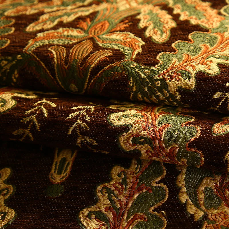 Un tissu décoratif de style oriental, avec des motifs floraux colorés et complexes sur un fond sombre, créant une texture luxueuse et raffinée.