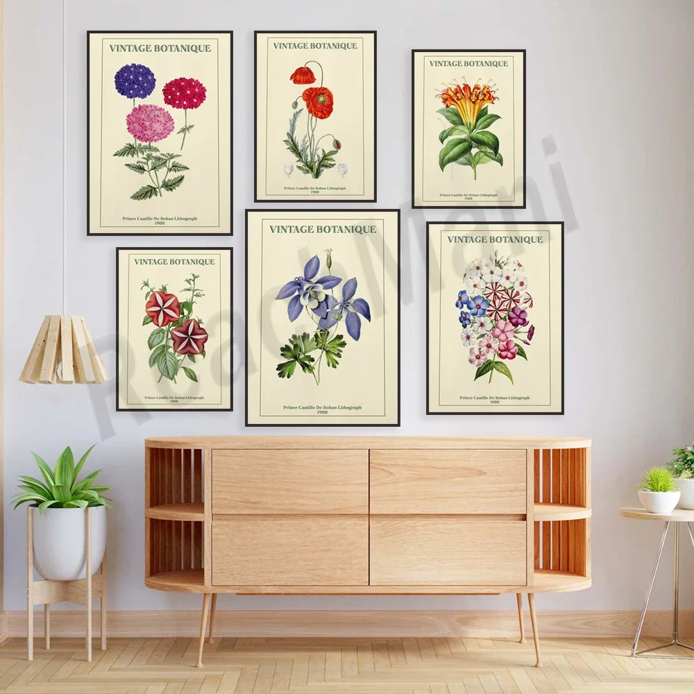 Cette image présente une collection d'affiches botaniques vintage encadrées, exposées sur un mur avec un meuble en bois en dessous. Les affiches montrent diverses plantes et fleurs colorées, chacune accompagnée du texte "VINTAGE BOTANIQUE".