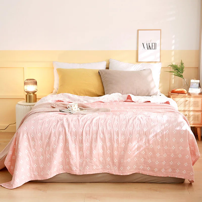 Chambre à coucher élégante avec un lit couverts de couvertures roses et de coussins, une lampe de chevet et un cadre mural avec le mot "Naked".