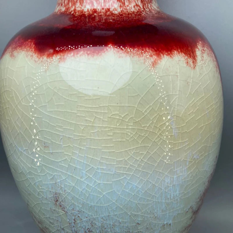 Un vase en céramique avec un motif de craquelures et un fini brillant.