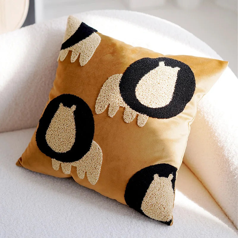 Coussin décoratif carré avec motif de yeux ou de monstres sur fond jaune, un élément de design amusant et ludique pour agrémenter un canapé ou un lit.