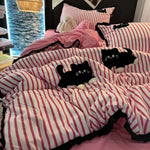 Parure de lit rayée avec chat rose brodé style coréen sur un lit