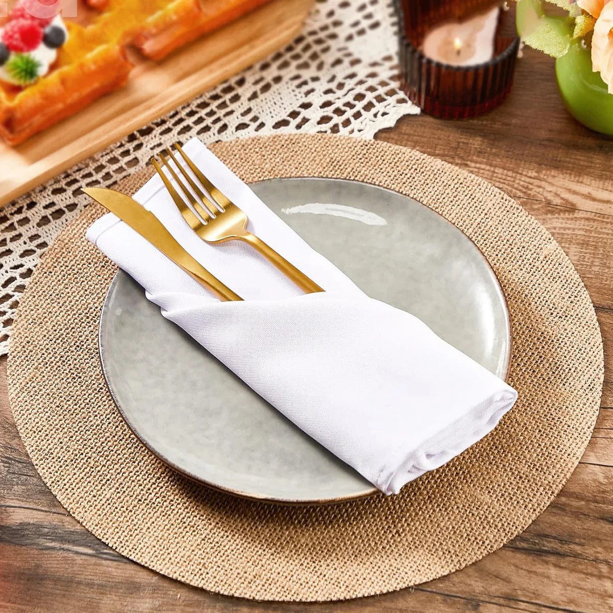 serviettes table beige feuilles artificielles rustique fourchettes dorées assiettes blanches vert classique decoration table