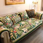 Un canapé tapissé de motifs tropicaux colorés, avec des coussins assortis disposés avec soin, créant une atmosphère chaleureuse et accueillante dans cette pièce élégante.