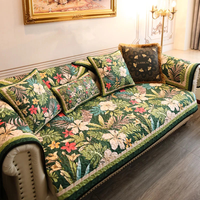 Un canapé tapissé de motifs tropicaux colorés, avec des coussins assortis disposés avec soin, créant une atmosphère chaleureuse et accueillante dans cette pièce élégante.