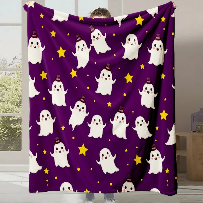 Couverture en polaire violette avec des motifs fantômes blancs et des étoiles jaunes, parfaite pour une ambiance Halloween cosy.