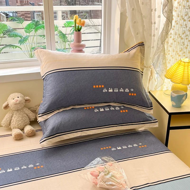 Ensemble de coussins décoratifs gris avec motifs graphiques orange dans un intérieur confortable, avec des accessoires de décoration tels qu'un vase de fleurs et une lampe de table.