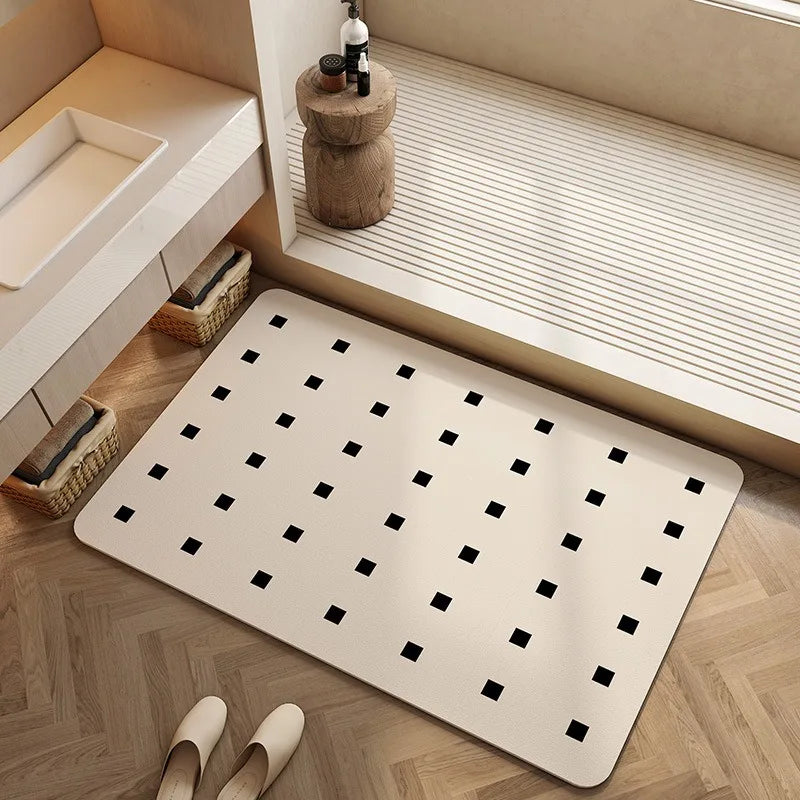Tapis rectangulaire blanc avec motifs carrés noirs, placé dans une pièce avec des étagères et un tabouret en bois.
