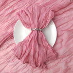 Élégante robe plissée rose poudrée sur une assiette blanche.