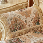 Un coussin orné de motifs floraux élégants et vintage, dans des nuances de beige et de marron, qui apporte une touche de luxe et de sophistication à l'environnement.