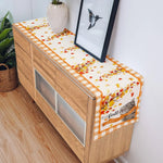 La console en bois avec des motifs de feuilles d'automne et une décoration de fleurs crée une ambiance chaleureuse et accueillante dans cette pièce.