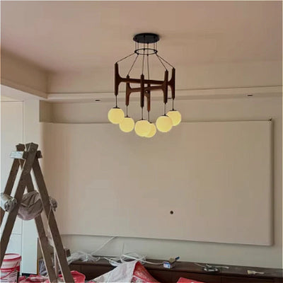 Lustre LED géométrique en bois crème suspendu dans une chambre parentale