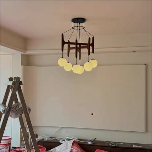 Lustre LED géométrique en bois crème suspendu dans une chambre parentale