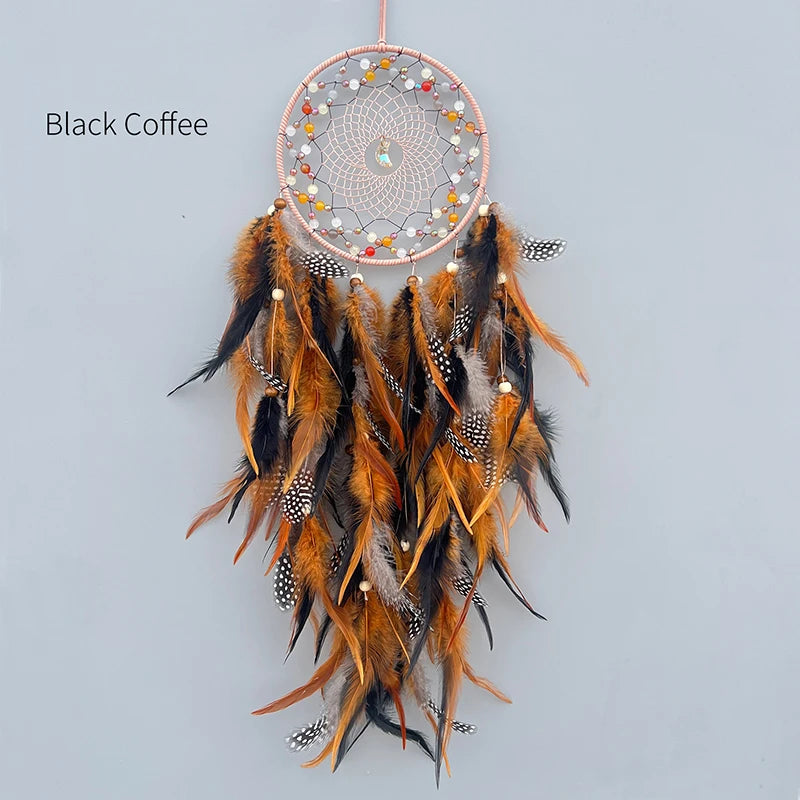 Un attrapeur de rêves artisanal en plumes de couleurs ocre et noires, avec des perles décoratives à l'intérieur, créant un design circulaire élégant.