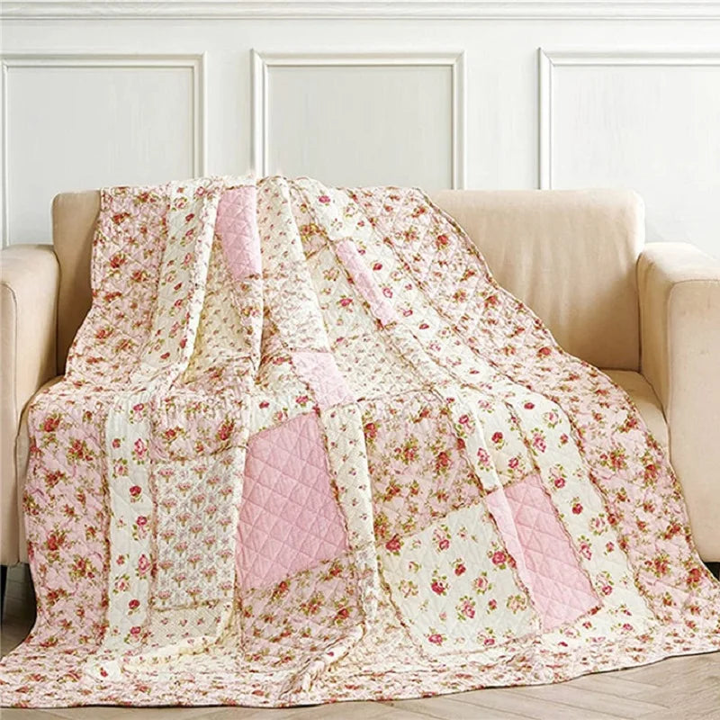Couvre-lit patchwork réversible en coton floral rose sur un lit