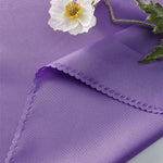 Une fleur blanche épanouie posée sur un fond violet avec une bordure ondulée.